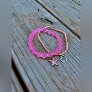 A starfish beaded bracelets, both with charms.Same Size and peachy/pink color